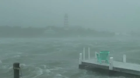 Hurricane force wind blowing across water with a lighthouse Stock Footage 12569243