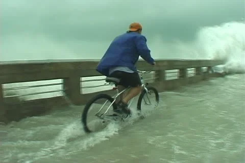 Hurricane wave nails cyclist Stock Footage 12575570