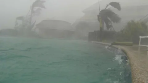 Hurricane wind blows water out of a swimming pool Stock Footage 33871366