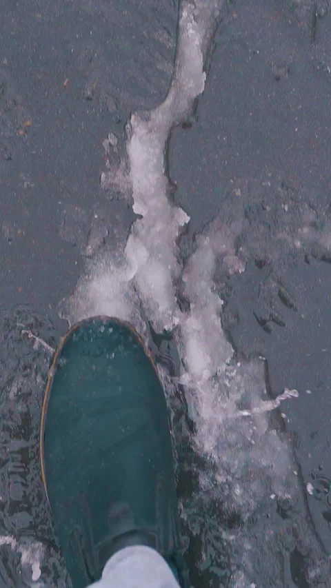 Hurrying man in boots walks fast along street with slush Stockbeeldmateriaal 317630614