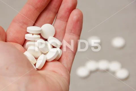 To hurt badly. Pills in the hand. The disease brings sadness. Stock Photos