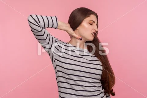 Hurting shoulders, stiff muscles. Portrait of tired sick woman in striped swe Stock Photos