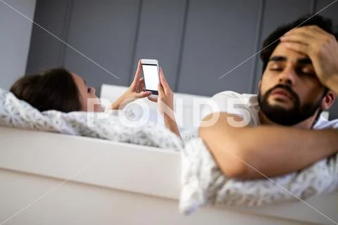 Husband is frustrated, upset while his internet addict wife is using mobile Stock Photos