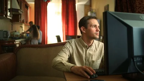 The husband gets frustrated working at the computer at home while his happy Video stock 74936181