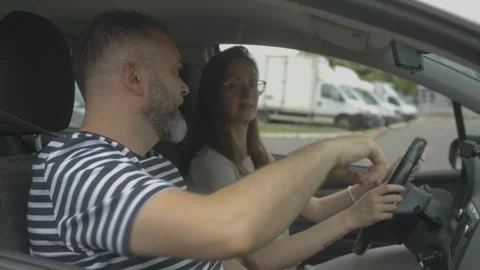 Husband giving driving lessons to his wife Stock Footage 337833157