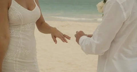 Husband Puts Ring on Wife's Finger During Beach Wedding Ceremony Stock Footage 112455068
