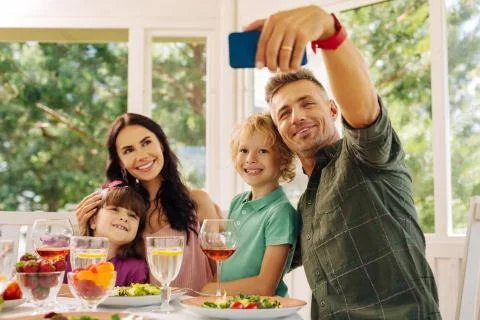 Husband taking his smartphone while making selfie with family Foto stock