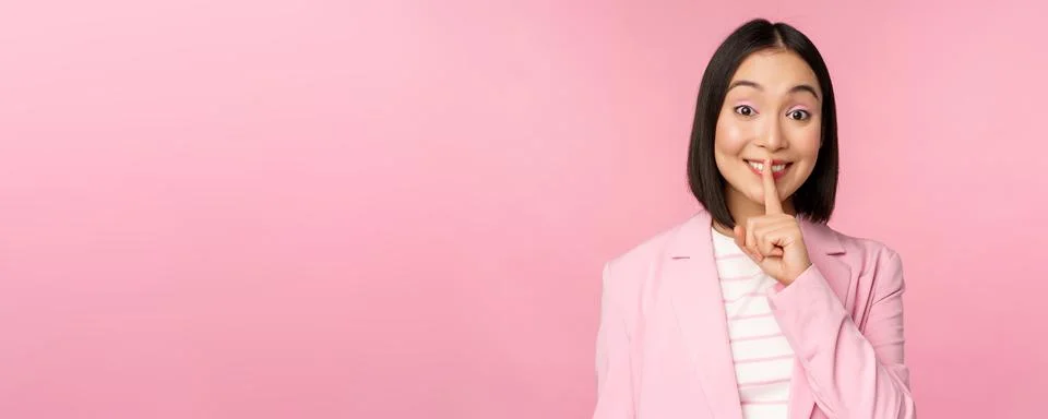 Hush, taboo concept. Portrait of asian businesswoman showing shush gesture, shhh Stock Photos