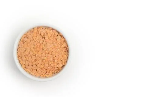 Husked split red lentils in white bowl. Stock Photos