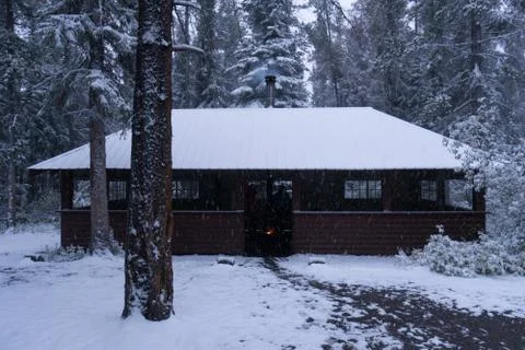Hut in the Canadian Rockies with snow and fire pit and pine trees Stock Photos