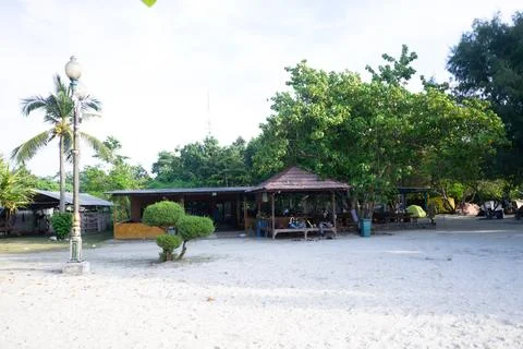A hut on the edge of a sandy beach with dense trees on pari island Stock Photos