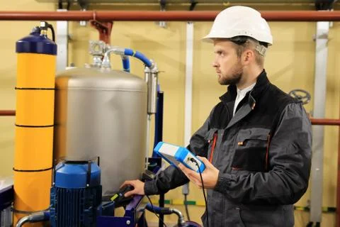 HVAC maintenance engineer checking technical data of heating system equipment Stock Photos
