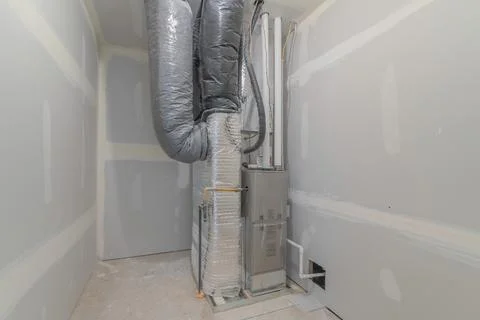 HVAC system inside a utility closet room with white markings on the wall Stock Photos
