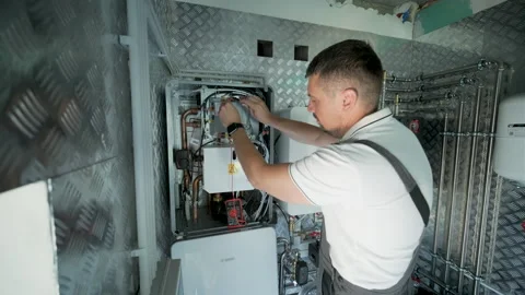 HVAC Technician Adjusting Heat Pump and Boiler System in Modern Mechanical Room Video stock 340112133
