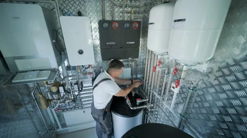HVAC Technician Adjusting Heat Pump and Boiler System in Modern Mechanical Room Stock Footage 340112170