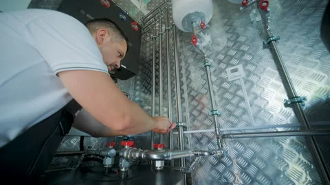 HVAC Technician Adjusting Heat Pump and Boiler System in Modern Mechanical Room Stock Footage 340112192