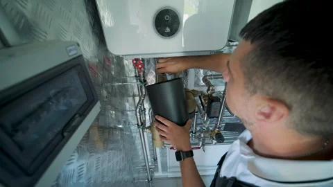HVAC Technician Adjusting Heat Pump and Boiler System in Modern Mechanical Room Stock Footage 340112289