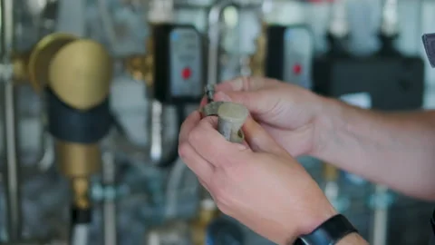 HVAC Technician Adjusting Heat Pump and Boiler System in Modern Mechanical Room Stock Footage 340112292