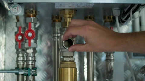 HVAC Technician Adjusting Heat Pump and Boiler System in Modern Mechanical Room Stock Footage 340112343