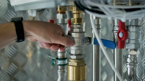 HVAC Technician Adjusting Heat Pump and Boiler System in Modern Mechanical Room Stock Footage 340112354