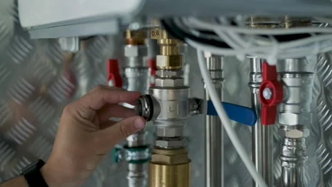 HVAC Technician Adjusting Heat Pump and Boiler System in Modern Mechanical Room Stock Footage 340112355