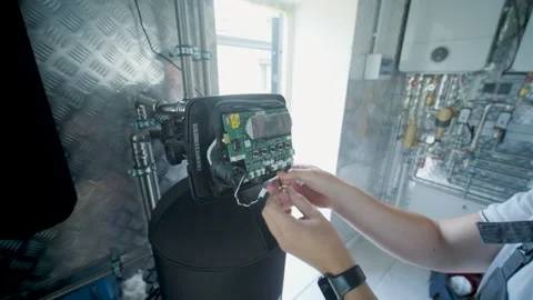 HVAC Technician Adjusting Heat Pump and Boiler System in Modern Mechanical Room Stock Footage 340112410
