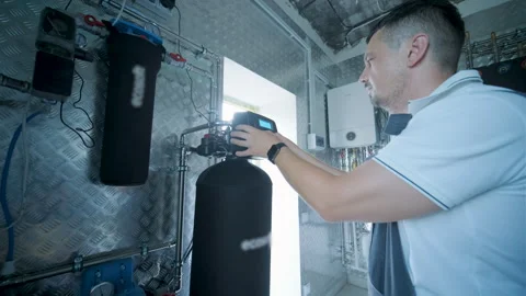 HVAC Technician Adjusting Heat Pump and Boiler System in Modern Mechanical Room Stock Footage 340112426
