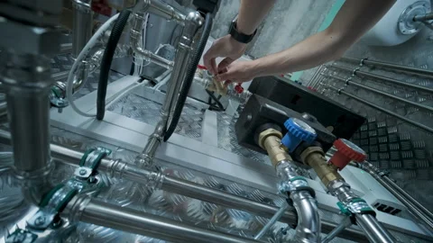 HVAC Technician Adjusting Heat Pump and Boiler System in Modern Mechanical Room Stock Footage 340112593