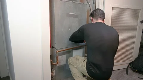 HVAC Technician Removing a Water Source Heat Pump Panel Stock Footage 148237346