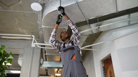 HVAC technician working on office ventilation system Stock Footage 309483947