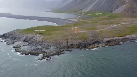 Hvalnes Lighthouse with steep and colored mountain Eystrahorn Stock-Footage 138709321