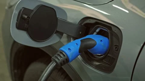 Hybrid Electric Car Socket with Plugged In Charger Cable Stock Footage 231018123