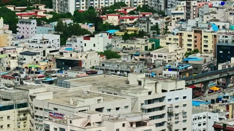Hyderabad Metro train passing through crowded residential buildings with Stock Footage 345277201