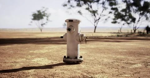 Hydrant standing alone in a dry landscape under a clear sky Stock Illustration