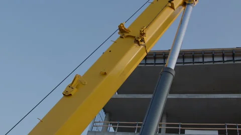 Hydraulic crane construction machine close-up in front of concrete building Stock Footage 242157303