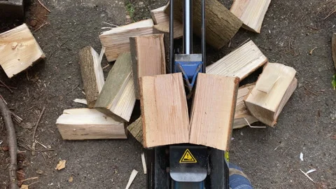 A hydraulic log splitter splitting a log Stock Footage 274343622