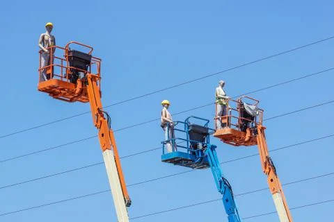 Hydraulic mobile construction platform elevated towards a blue sky with false Stock Photos