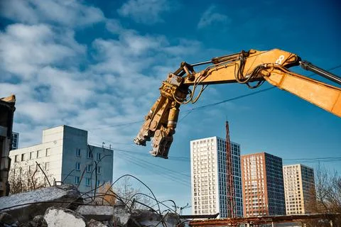 Hydraulic scissors on rigging to cut abandoned buildings Stock Photos