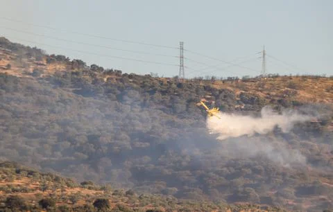 Hydro plane throwing water for fire extinction with deep blue sky on background Stock Photos