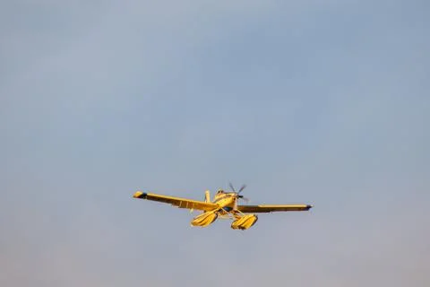 Hydro plane throwing water for fire extinction with deep blue sky on background Stock Photos