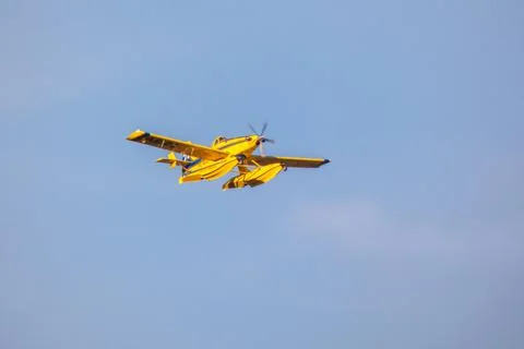 Hydro plane throwing water for fire extinction with deep blue sky on background Stock Photos
