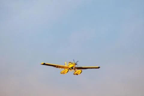 Hydro plane throwing water for fire extinction with deep blue sky on background Stock Photos