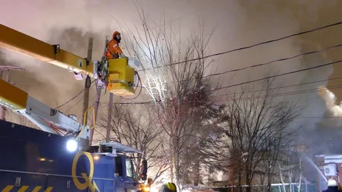 Hydro Quebec power company worker on a truck with platform at fire Stock Footage