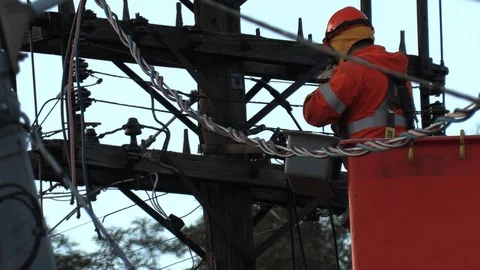 Hydro worker on power pole making repairs to high voltage lines Stock Footage 98431573