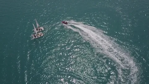 Hydrocycle rides around the catamaran in the Black sea viewing from drone in Stock Footage 77707772