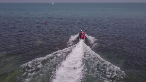 Hydrocycle rides around the catamaran in the Black sea viewing from drone in Stock Footage 77707779