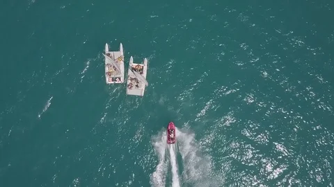 Hydrocycle rides around the catamaran in the Black sea viewing from drone in Stock Footage 77707793
