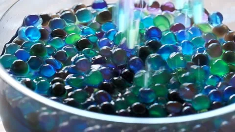 Hydrogel Orbeez. multicolored orbiz balls pours  into a cup. Stock Footage 221042209