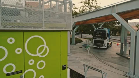 Hydrogen compressor unit standing near refueling station canopy filmed via low Vídeo Stock 333964639