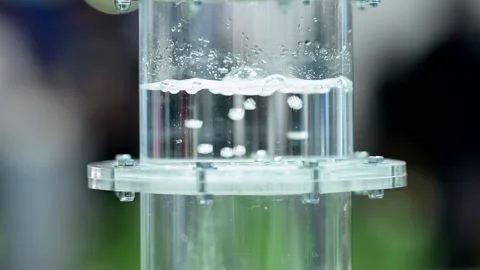 Hydrogen gas bubbeling through a membrane in a plastic cylinder filled Stock Footage 252107866